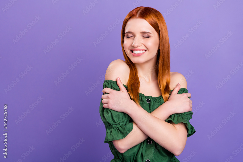 Photo of enjoy red hair millennial lady hug herself wear green blouse isolated on violet background Photo of enjoy red hair millennial lady hug herself wear green blouse isolated on violet background