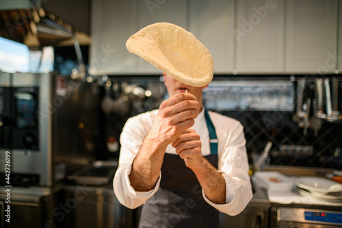 Tablou pe pânză selective focus on the dough that the chef throws up the air