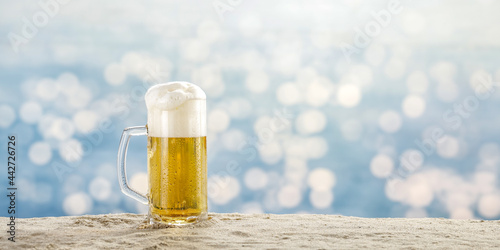 Cold beer on sand and sea landscape 