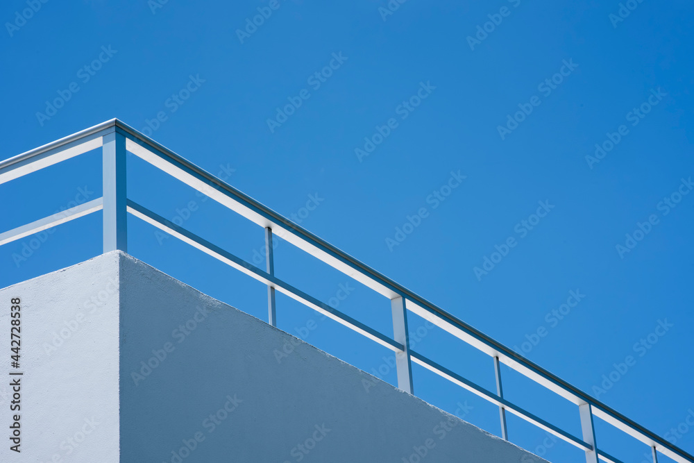 A view from below a building railing against the blue sky, Cozumel island, Mexico. A view from below a building railing against the blue sky, Cozumel island, Mexico.