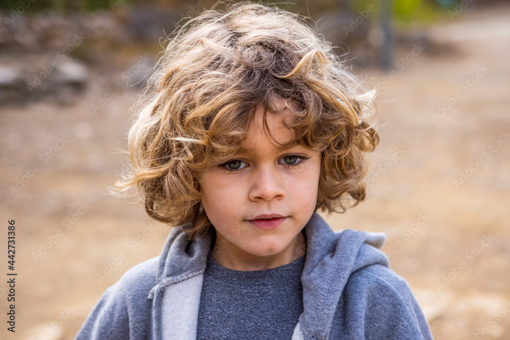 Boy in hoodie with wavy hair in daytime Boy in hoodie with wavy hair in daytime