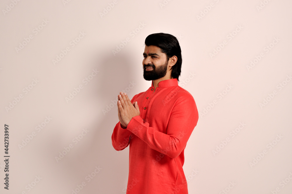 handsome Indian man wearing kurta smiling making Namaste gesture with hands, Side view
handsome Indian man wearing kurta smiling making Namaste gesture with hands, Side view