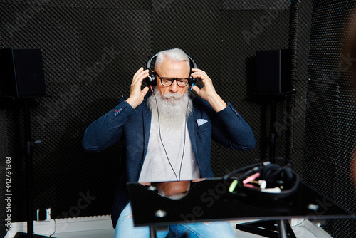 Senior man in headphones during audiology test photo