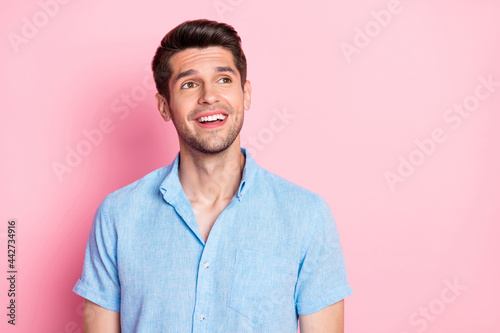 Photo portrait smiling man in blue shirt looking blank space isolated pastel pink color background © deagreez