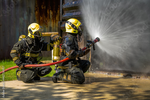 Firefighters are conducting fire drills by spraying water to extinguish the raging fire. © MAGNIFIER