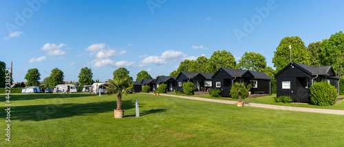 Photo panorama view of an idyllic campground in Denmark with little black glamping hos