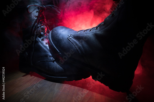 War concept. Old military shoe in a dark toned foggy background. Creative concept of conflict between countries, military aggression. © zef art