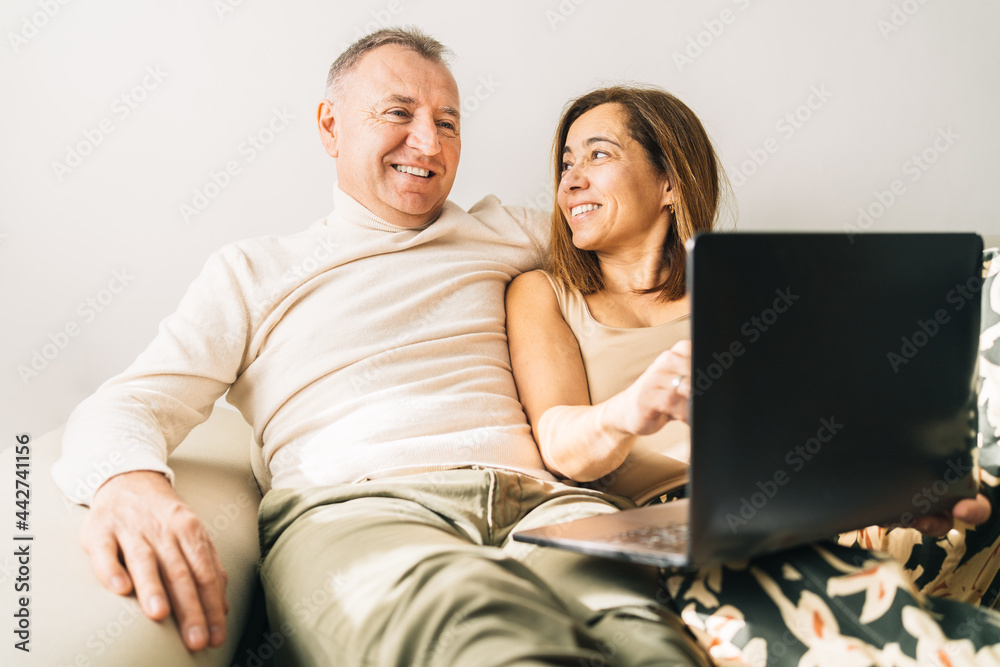 Content couple watching movie on laptop at home Content couple watching movie on laptop at home