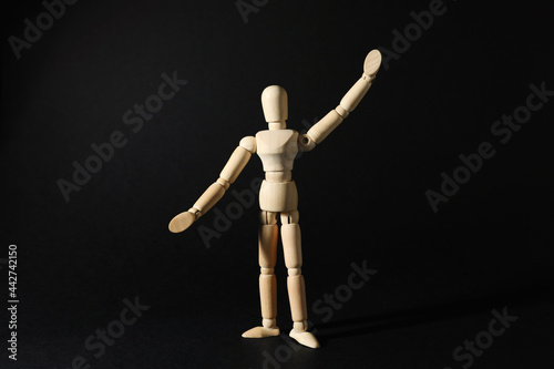 Wooden human model on black background. Mini mannequin