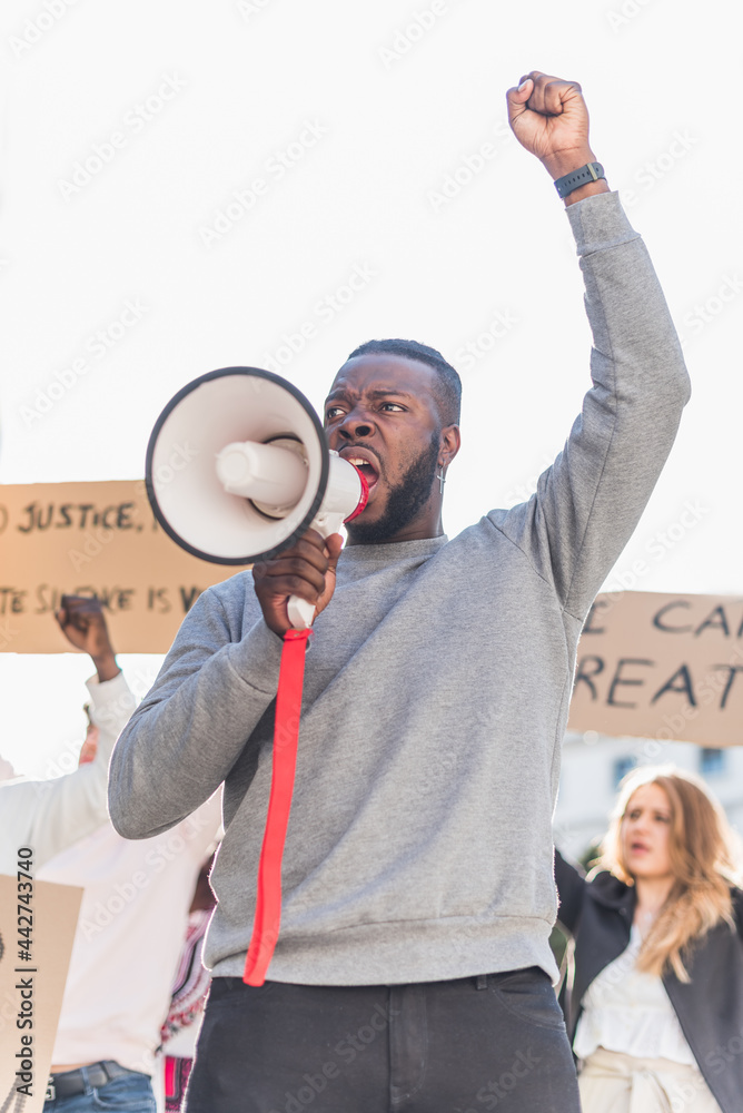 Black man protesting with megaphone in street Black man protesting with megaphone in street