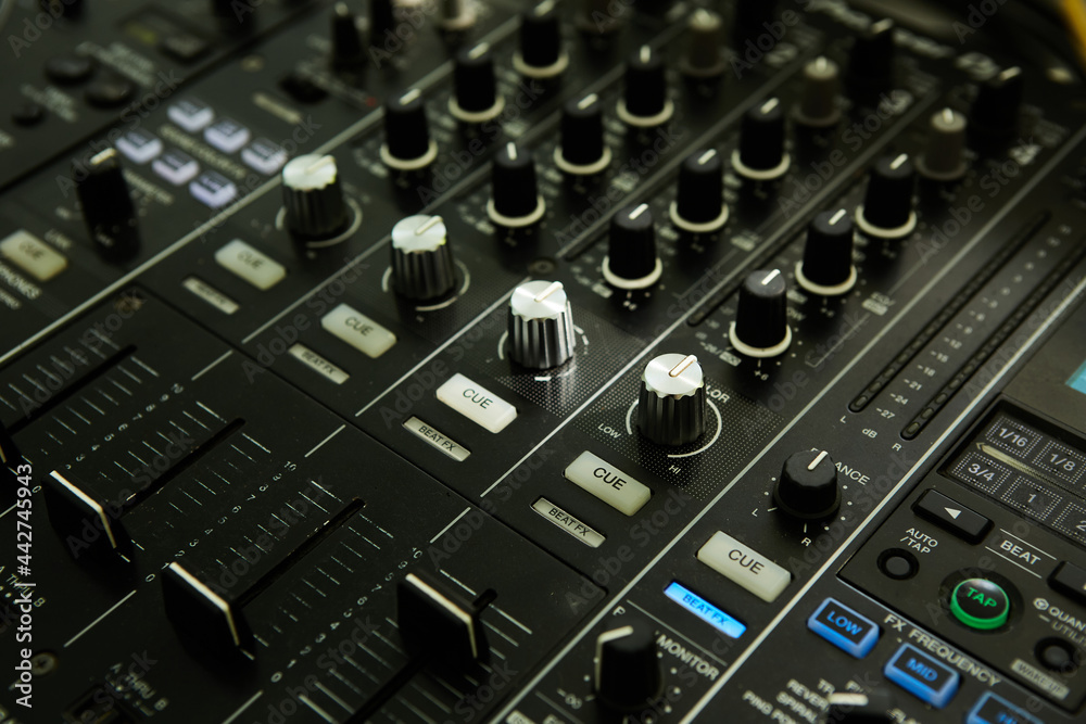 Wide angle photo of black sound mixer controller with knobs and sliders Wide angle photo of black sound mixer controller with knobs and sliders