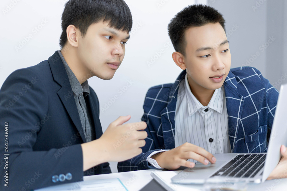 Business partners concept two young male producers discussing and changing ideas for developing a model of a new project Business partners concept two young male producers discussing and changing ideas for developing a model of a new project