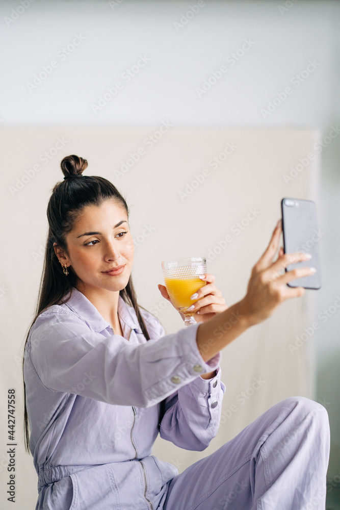 Charming woman with beverage taking selfie on smartphone at home Charming woman with beverage taking selfie on smartphone at home