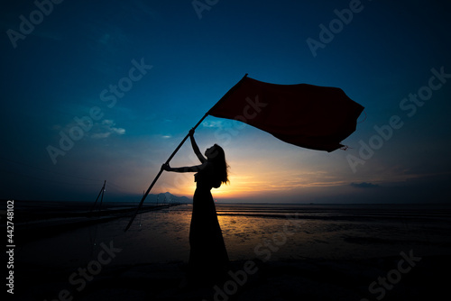 旗を持つ女性のシルエット