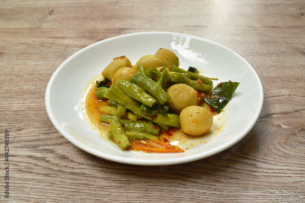 spicy fried fish ball with slice yard long bean in curry sauce on dish spicy fried fish ball with slice yard long bean in curry sauce on dish