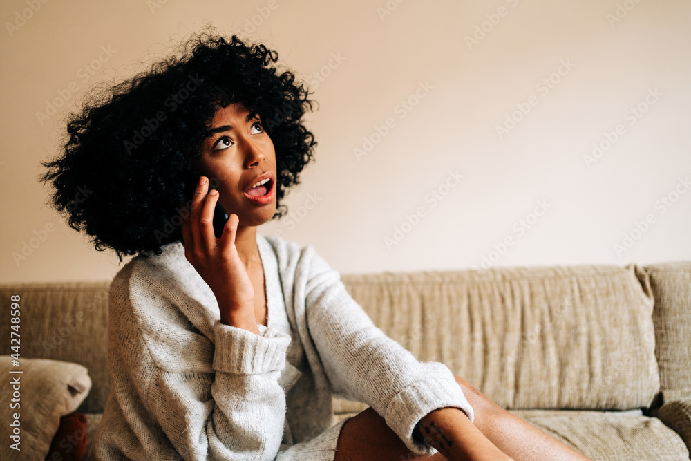 Funny black woman speaking on smartphone at home Funny black woman speaking on smartphone at home