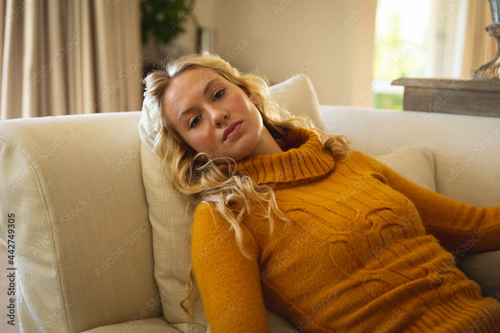 Portrait of thoughtful caucasian woman lying back on couch relaxing n luxury living room Portrait of thoughtful caucasian woman lying back on couch relaxing n luxury living room