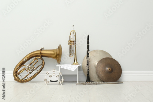 Leinwand Poster Different percussion and wind musical instruments near white wall indoors