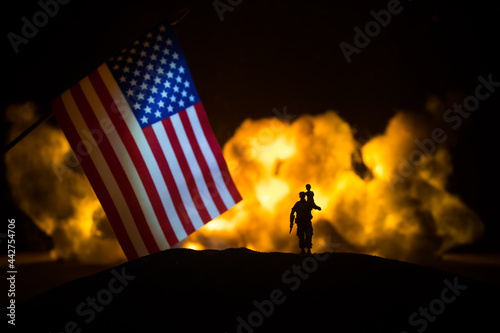 US small flag on burning dark background. Concept of crisis of war and political conflicts between nations. photo