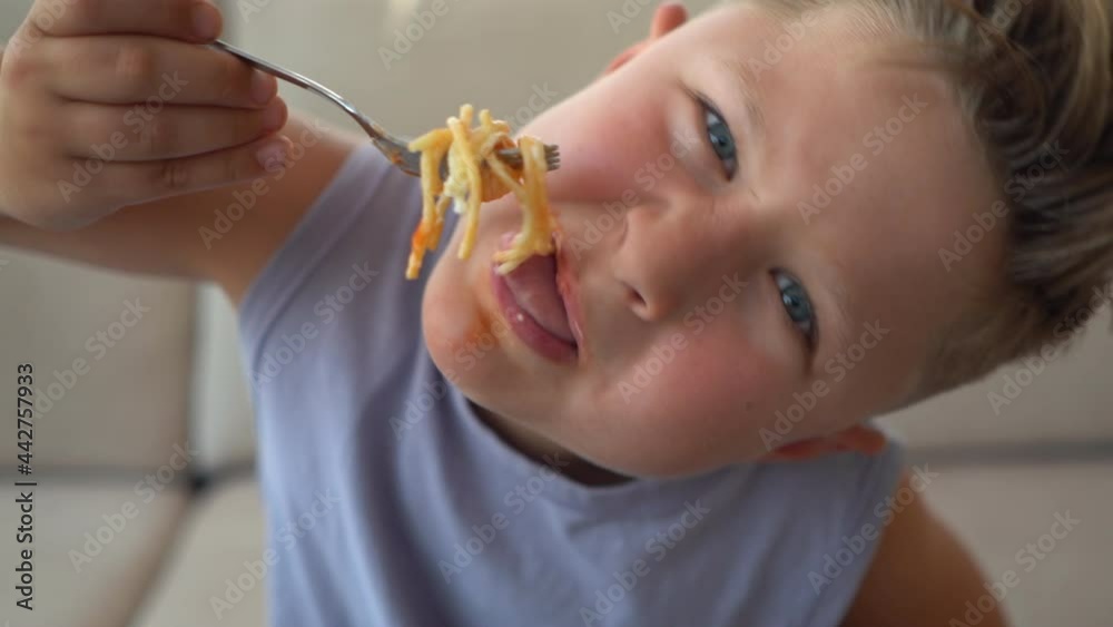 Niño comiendo espaguetis largos