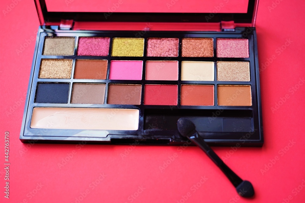 Set of eye shadows in a black box on the red table Set of eye shadows in a black box on the red table