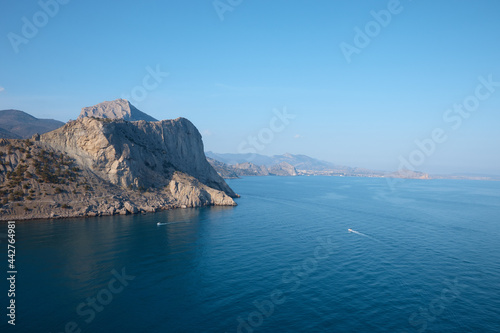 rocky shore in the sea, wild beach and mountains, the rock goes into the water, sea view, wild landscape