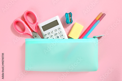 School supplies set top view on pink empty space background. Pencil case with accessories. Back to school photo