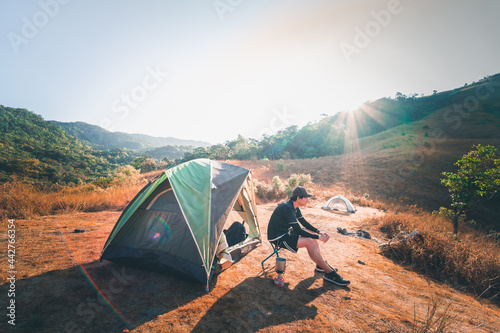 wanderlust and relax in nature with hiker man camping on top of mountain on spring and summer season