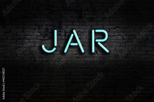 Neon sign. Word jar against brick wall. Night view