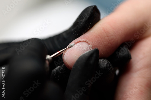 Fotografie Professional hardware manicure on an electric machine in a nail salon