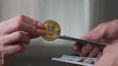 Exchange cryptocurrency bitcoin for US dollars. Close-up of hands with bitcoin and money.