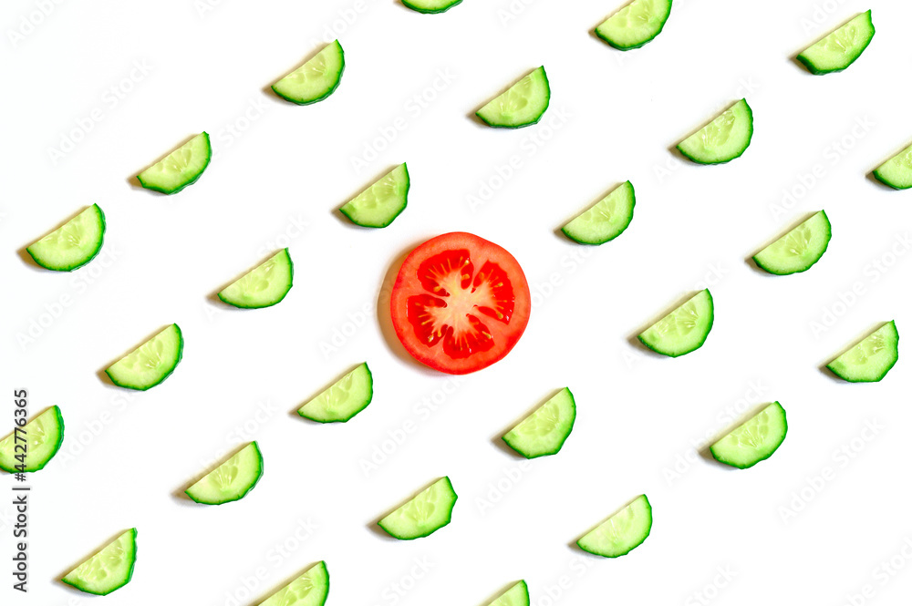 repeating pattern of sliced semicircles of fresh raw vegetable cucumbers for salad and a slice of tomato in the center isolated on a white background flat lay, top view repeating pattern of sliced semicircles of fresh raw vegetable cucumbers for salad and a slice of tomato in the center isolated on a white background flat lay, top view