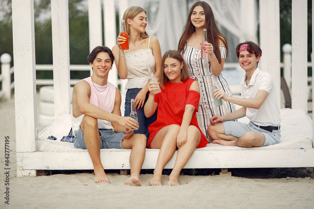 Friends have fun on a beach with drinks Friends have fun on a beach with drinks