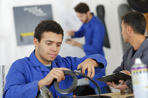 car mechanic man at the garage fixing the engine