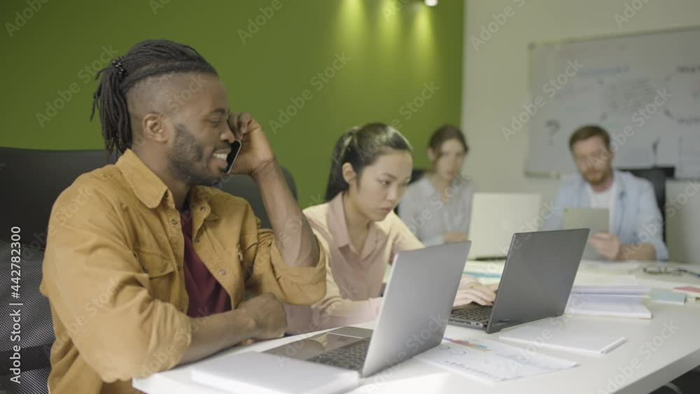 Office worker having loud phone conversation at work, disturbing other employees Office worker having loud phone conversation at work, disturbing other employees