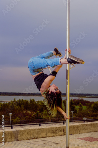 Woman practicing Poledance on square poles