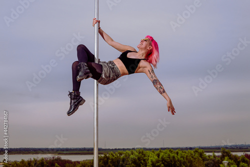 Woman practicing Poledance on square poles