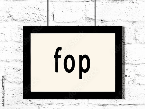 Foto Black frame hanging on white brick wall with inscription fop