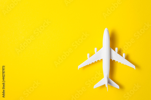 Flat lay design of travel concept with plane on yellow background with place for text.