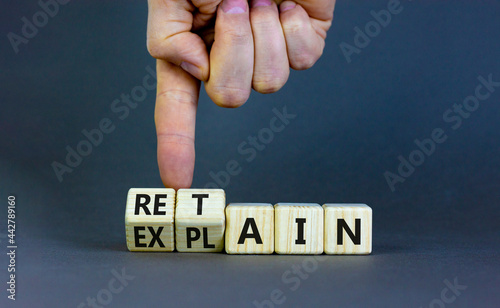 Retain or explain symbol. Businessman turns wooden cubes and changes the word explain to retain. Beautiful grey background. Business, retain or explain concept. Copy space.