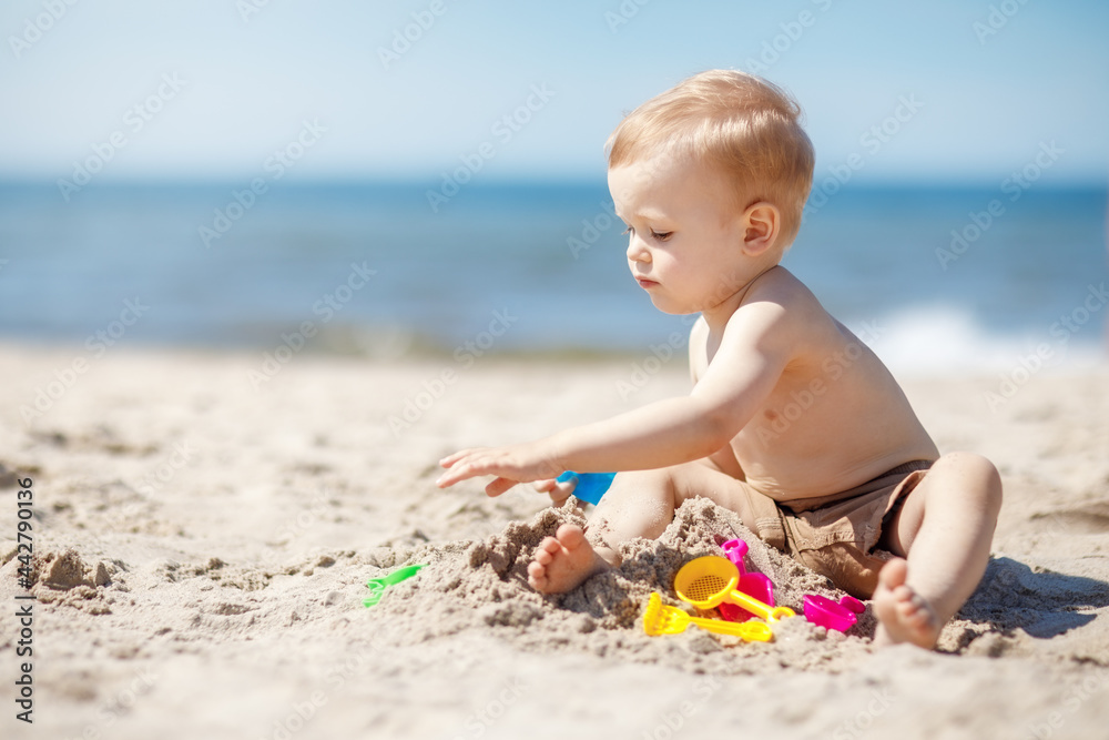 Baby boy play on beach, sand near sea Baby boy play on beach, sand near sea