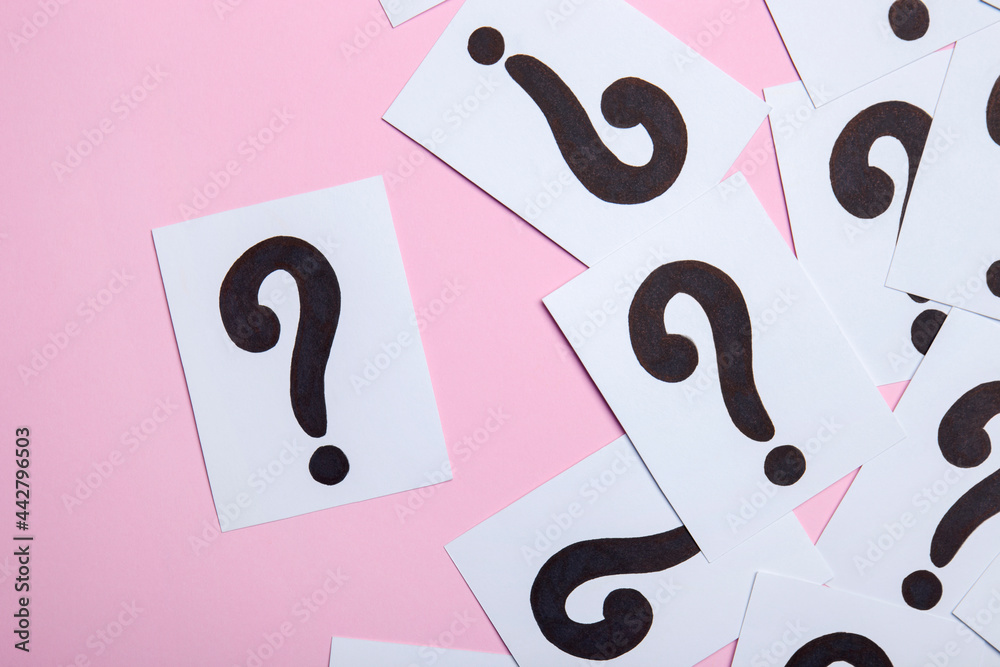 Paper cards with question marks on pink background. Pile of question marks, top view Paper cards with question marks on pink background. Pile of question marks, top view