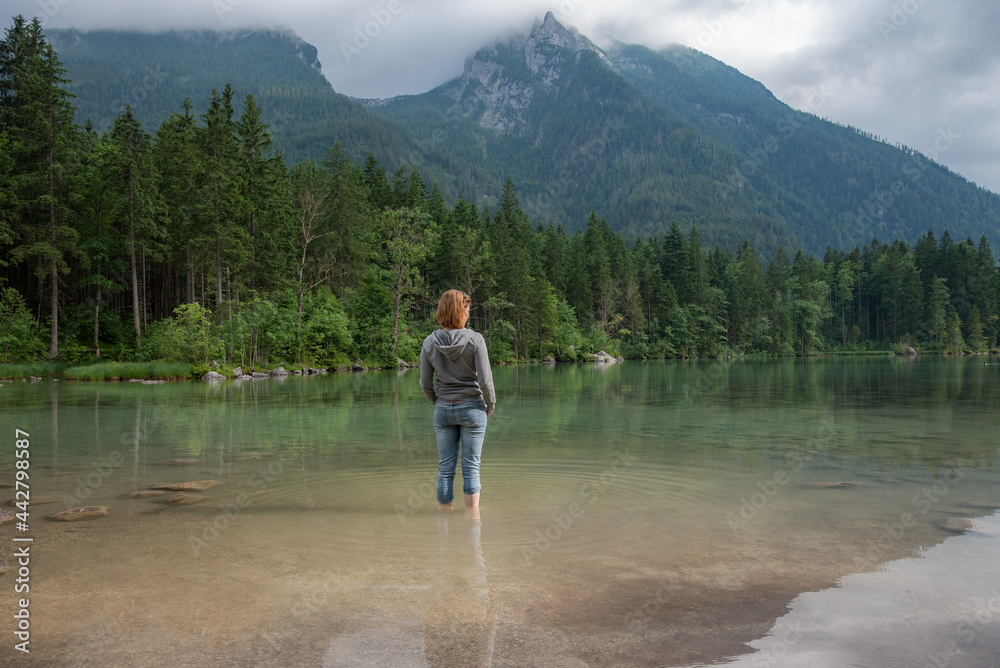 Young woman taking a break at the lake close to the mountains Young woman taking a break at the lake close to the mountains