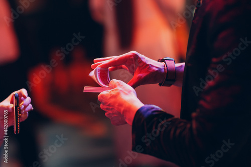 magician shows guests card tricks at the party close up hands.