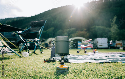 small portable cooking stove boiling water on a family campsite photo