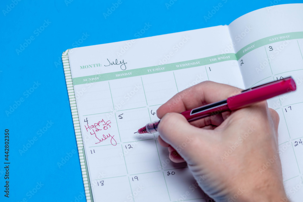 Planner schedule calendar and to do list reminder agenda work from home concept with happy July 4th handwritten down in book isolated on blue background Planner schedule calendar and to do list reminder agenda work from home concept with happy July 4th handwritten down in book isolated on blue background