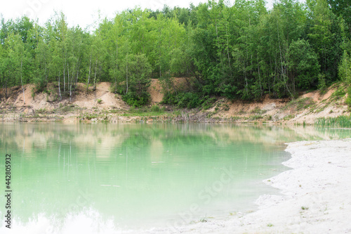 Fototapeta Naklejka Na Ścianę i Meble -  Flooded kaolin mine with green water and white clay in Brasy in Czechia.