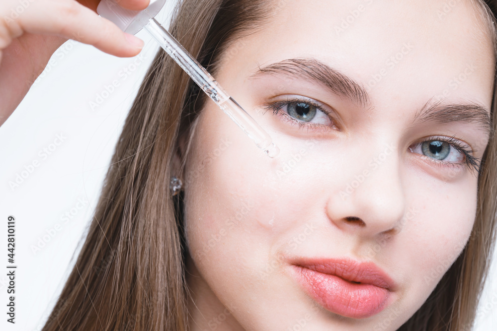 Close up photo. A beautiful girl with clean skin applies serum to her face with a pipette. Skin care Close up photo. A beautiful girl with clean skin applies serum to her face with a pipette. Skin care