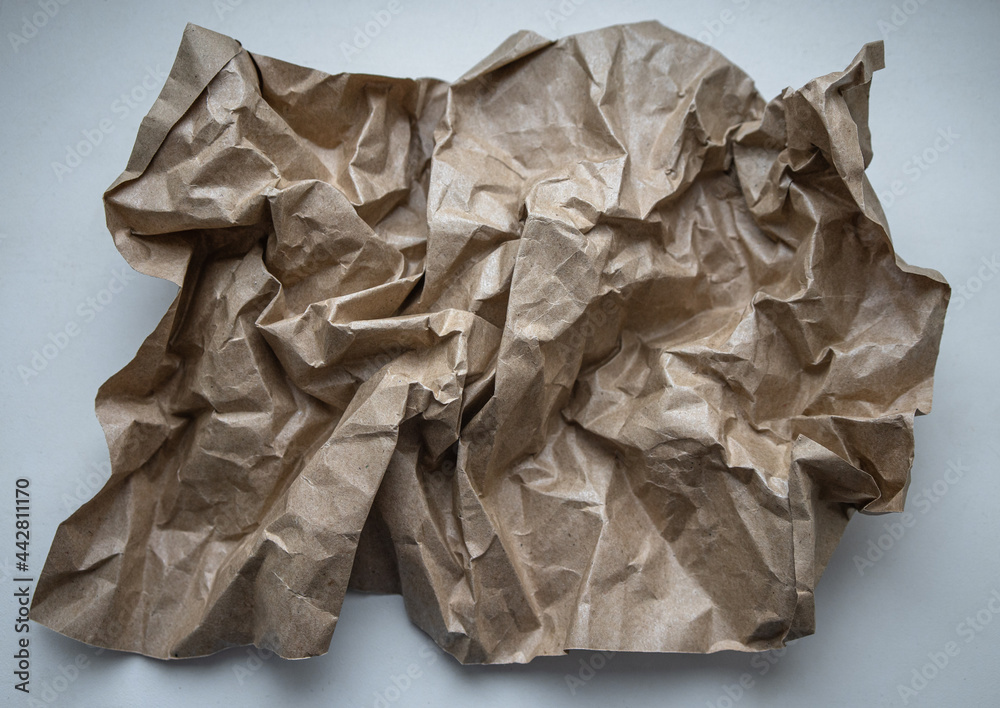 A lump of crumpled brown wrapping paper on a white isolate.