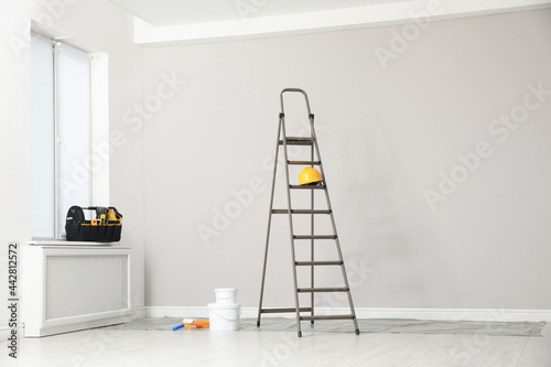 Ladder, decorator's tools and box with instruments in room